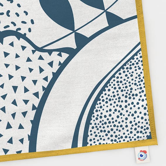 Torchon Tropico fond naturel imprimé bleu famille Tropico Coco. Couleur moutarde, bleu canard motifs tropical, végétal.